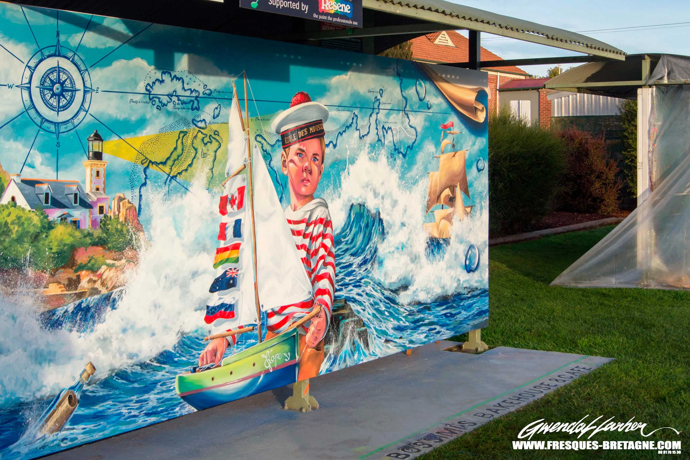 Fresque murale peinte pour l'International Mural Fest à Sheffield, en Tasmanie : jeune mousse en marinière rayée devant un voilier orné de pavillons